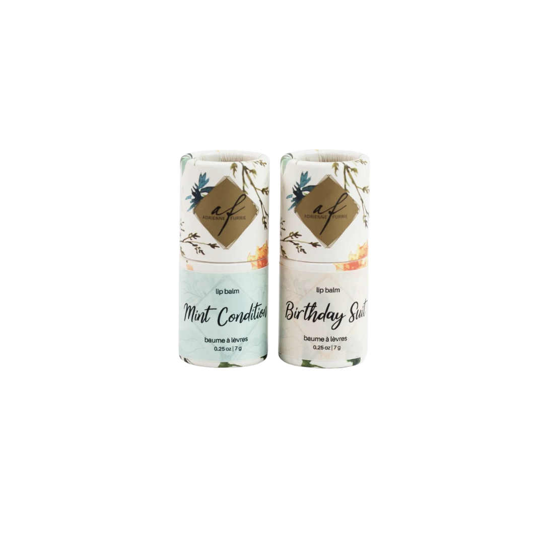 Two all-natural lip balms with beeswax, with floral patterns and labels 'Mint Condition' and 'Birthday Suit' respectively, against a white background.