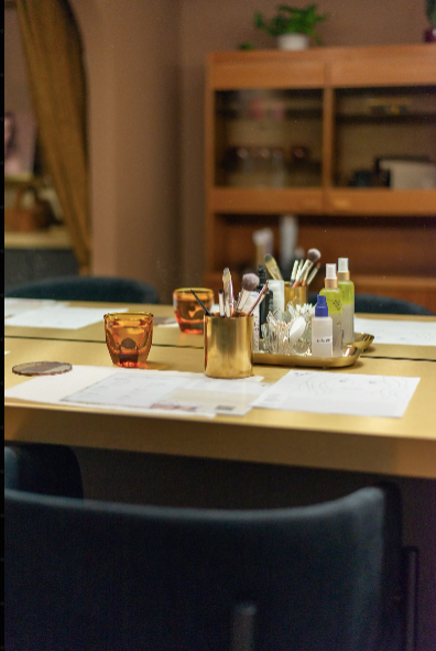 Table setup with glasses, stationery, and small bottles in a room.