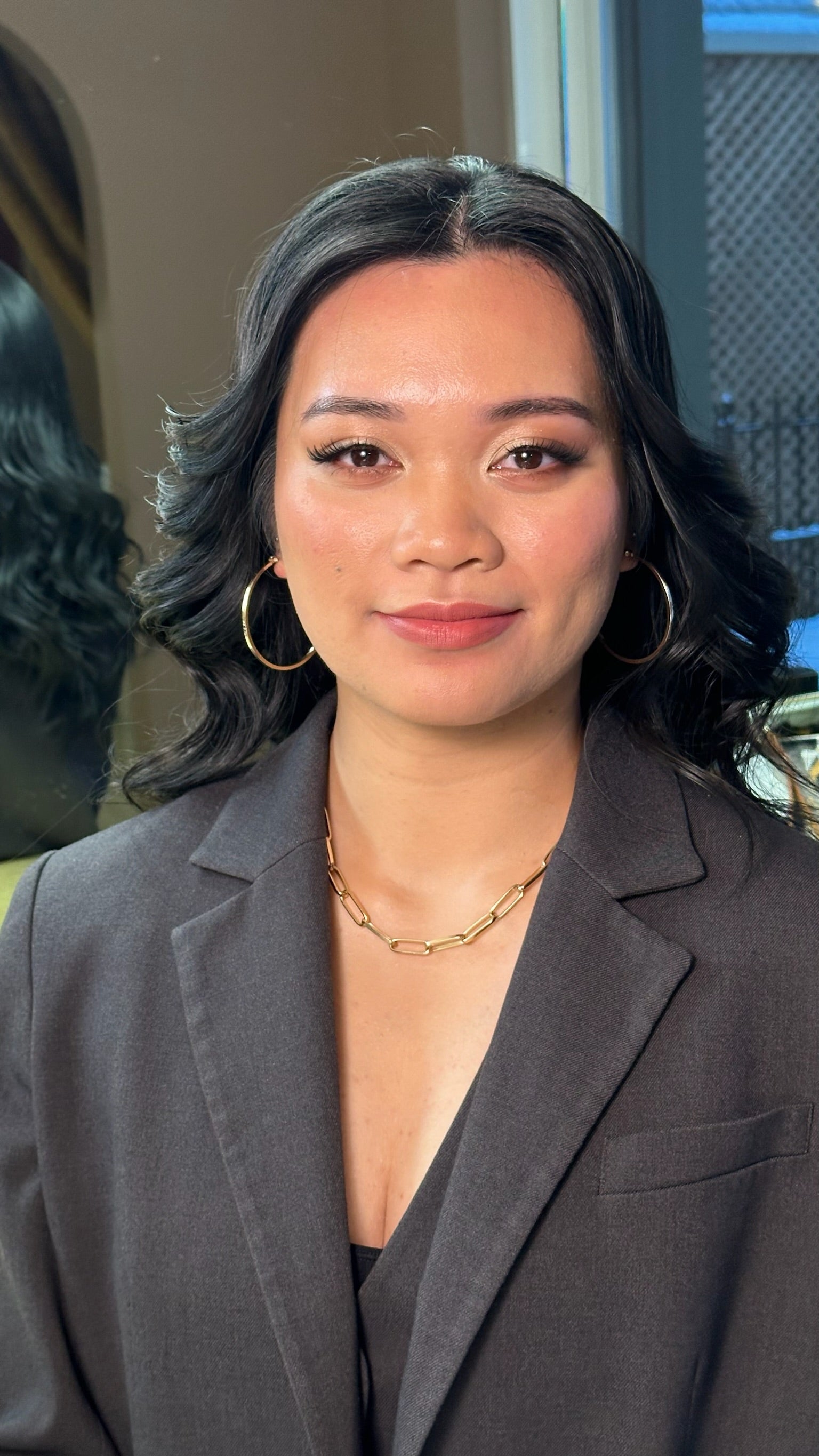 Woman wearing a gray blazer with a blurred background